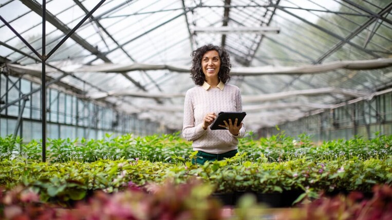 Frau mit Tablet bei der Gartenarbeit