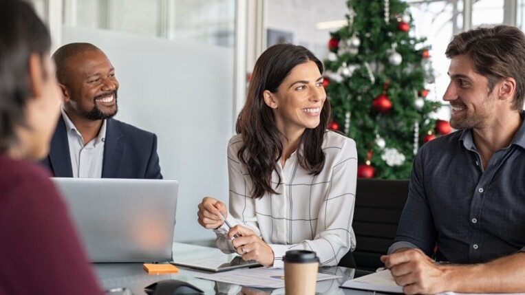 Kollegen in einem weihnachtlich dekorierten Büro