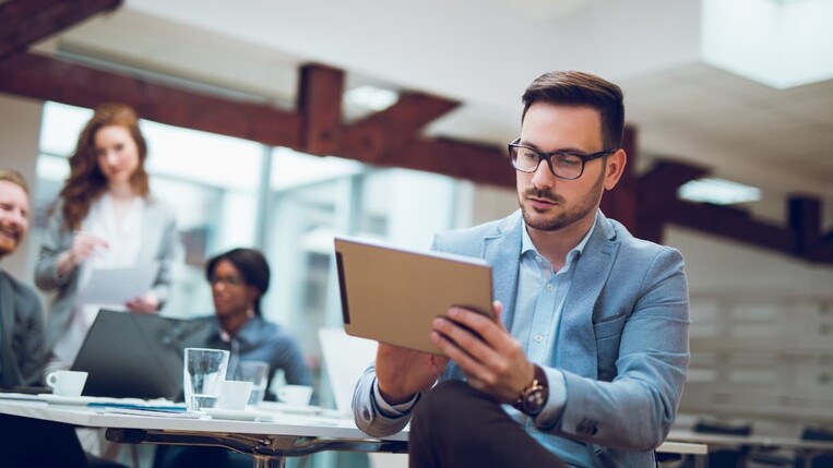 Man reading a white paper on a tablet