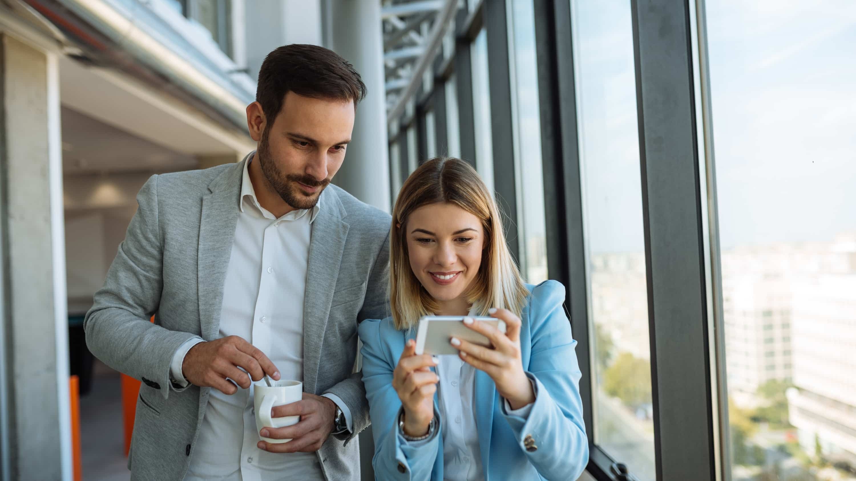 deux collègues regardent leur smartphone