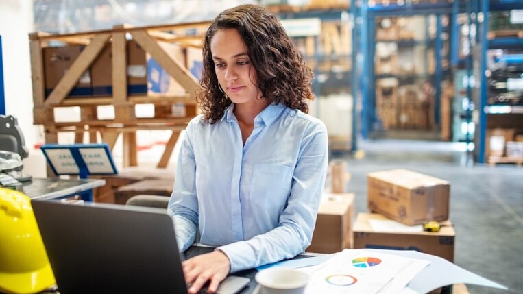 Frau arbeitet im Lager am Computer